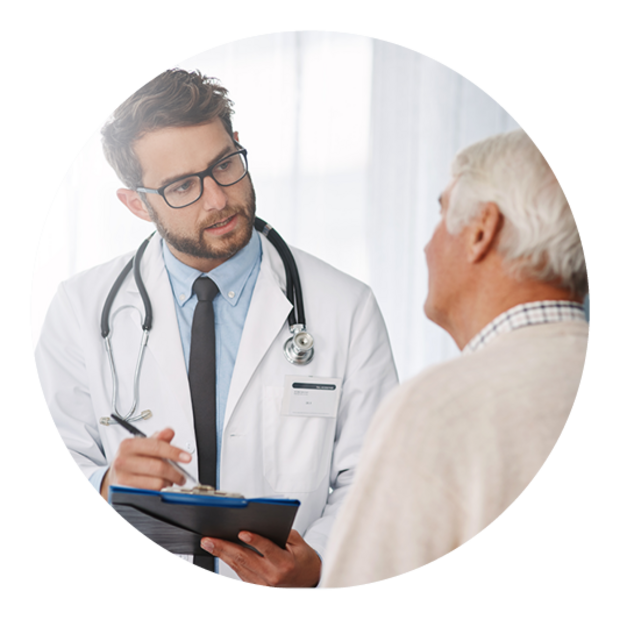 Eine jungen Arzt, der mit seinem älteren männlichen Patienten Krankenakten durchgeht.